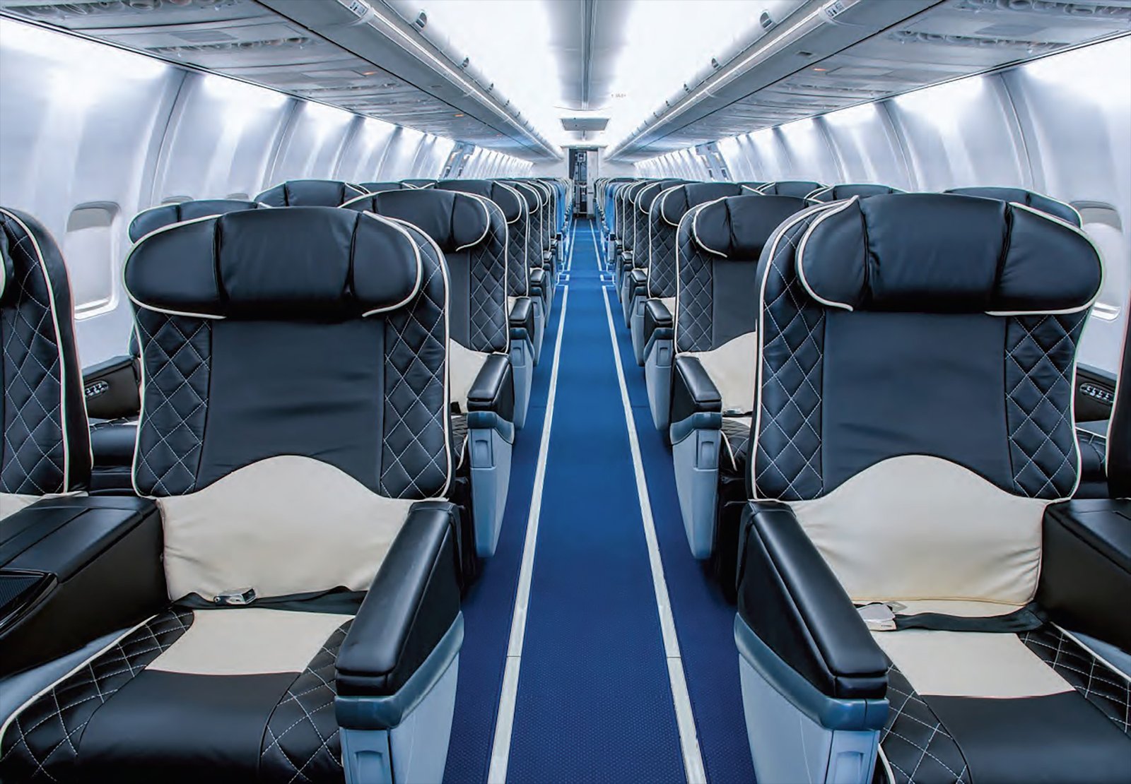 Rows of quilted leather seats down the aisle of a jet cabin