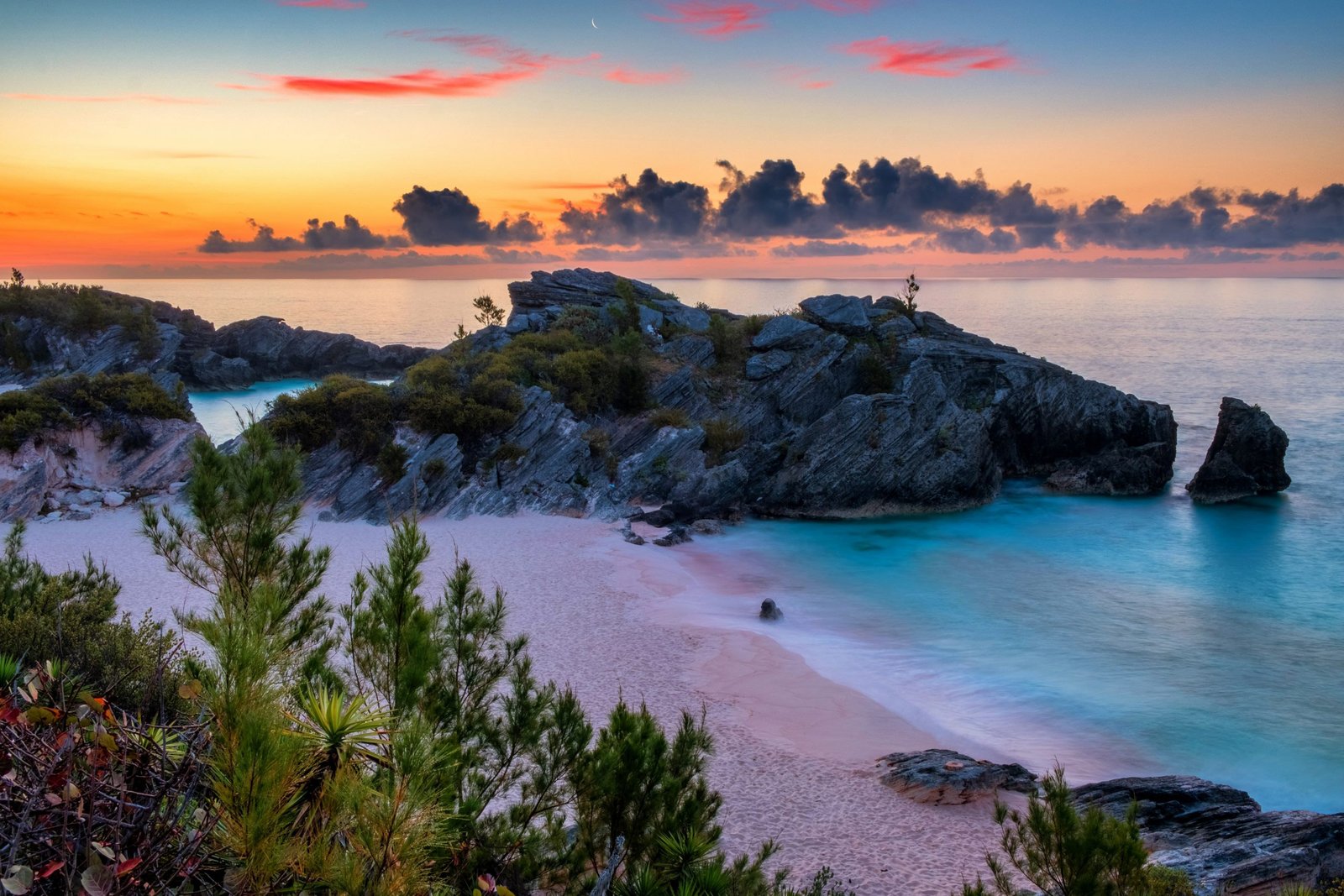 Pink sand cove framed by limestone rock formations and turquoise water