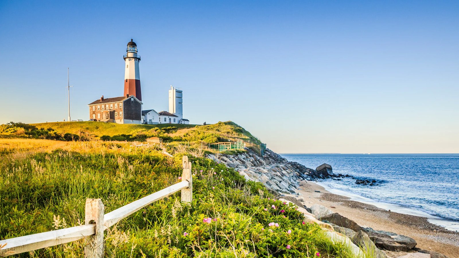 Montauk Point Lighthouse on a grassy bluff above the beach