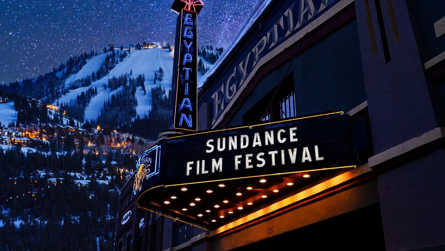 Sundance Film Festival marquee lit at night on Main Street with a snowy ski hill behind